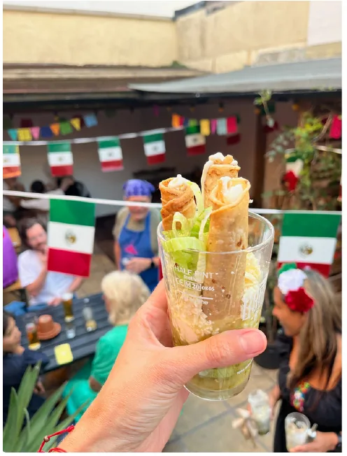 Crispy Mexican flautas served upright at an outdoor event
